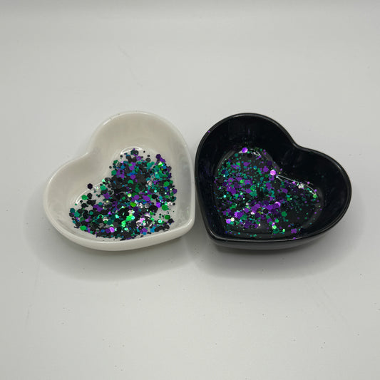 Two heart shaped containers, one black, one white, containing a Blue/Green/Black/Purple chunky glitter mix.