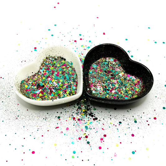 Two heart shaped containers, one black, one white, containing a Light Teal/Pink/Yellow chunky glitter mix.
