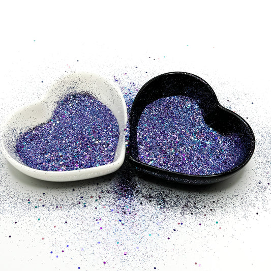 A white and black heart shaped dish showing a Purple/Blue/Pink medium glitter mix.