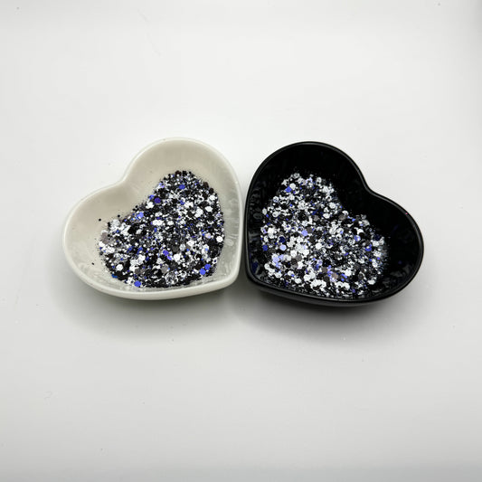 Two heart shaped containers, one black, one white, containing a Light Black/Blue/White chunky glitter mix.
