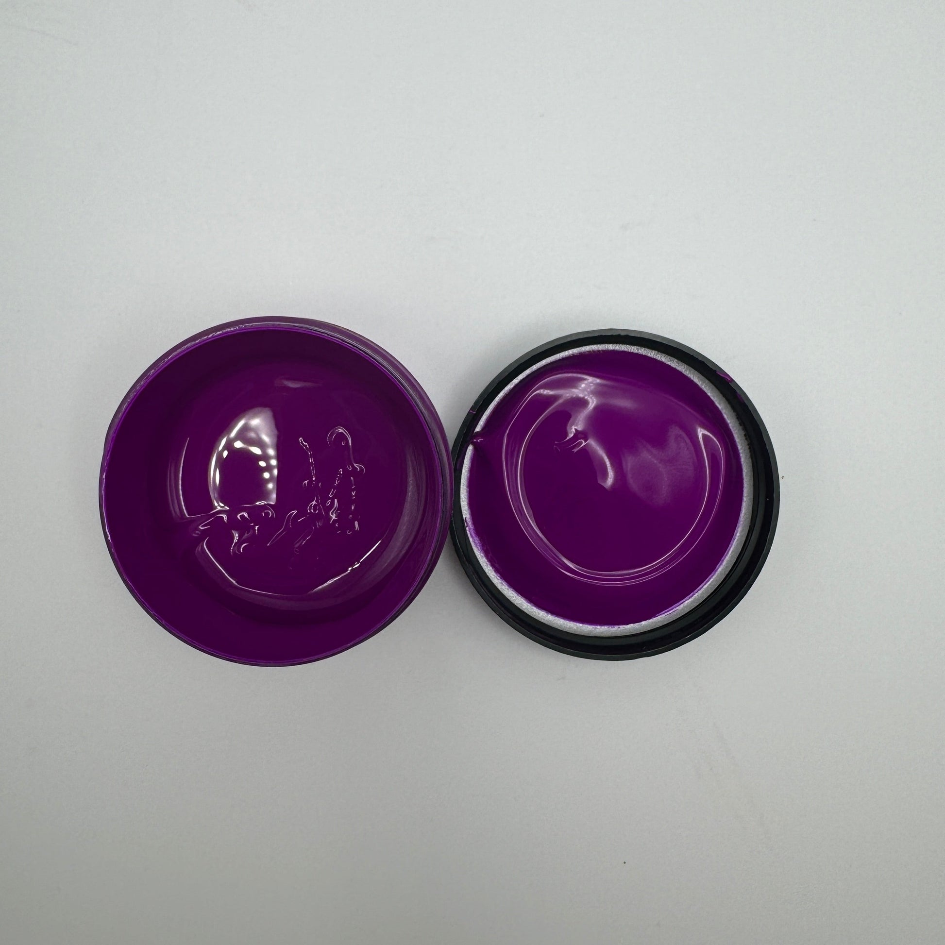 A jar of electric purple pigment paste opened to display the purple-coloured product inside.