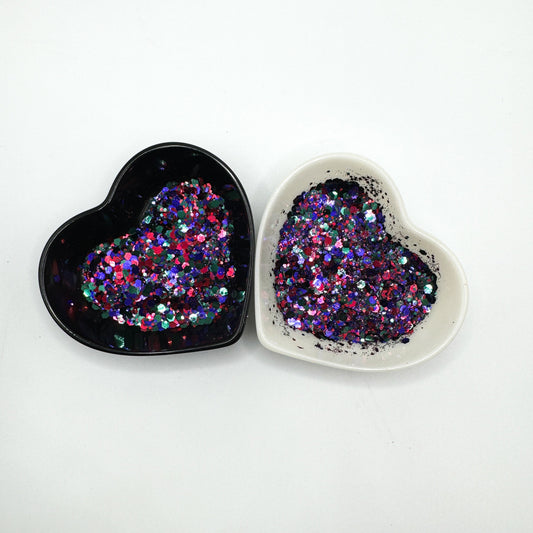 Two heart shaped containers, one black, one white, containing a Pink/Green/Indigo chunky glitter mix.