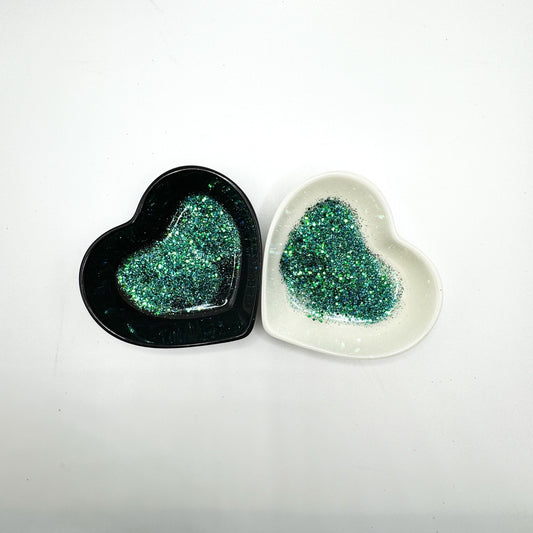 A white and black heart shaped dish showing a Blue/Green medium glitter mix.