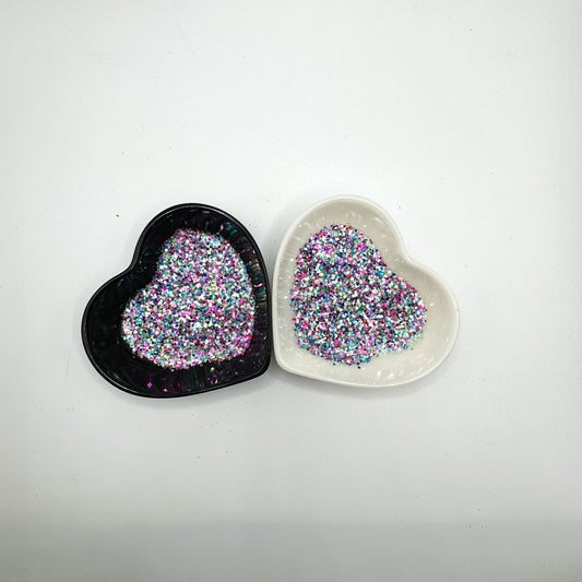 A white and black heart shaped dish showing a White/Rainbow/Pink/Purple/Green medium glitter mix.