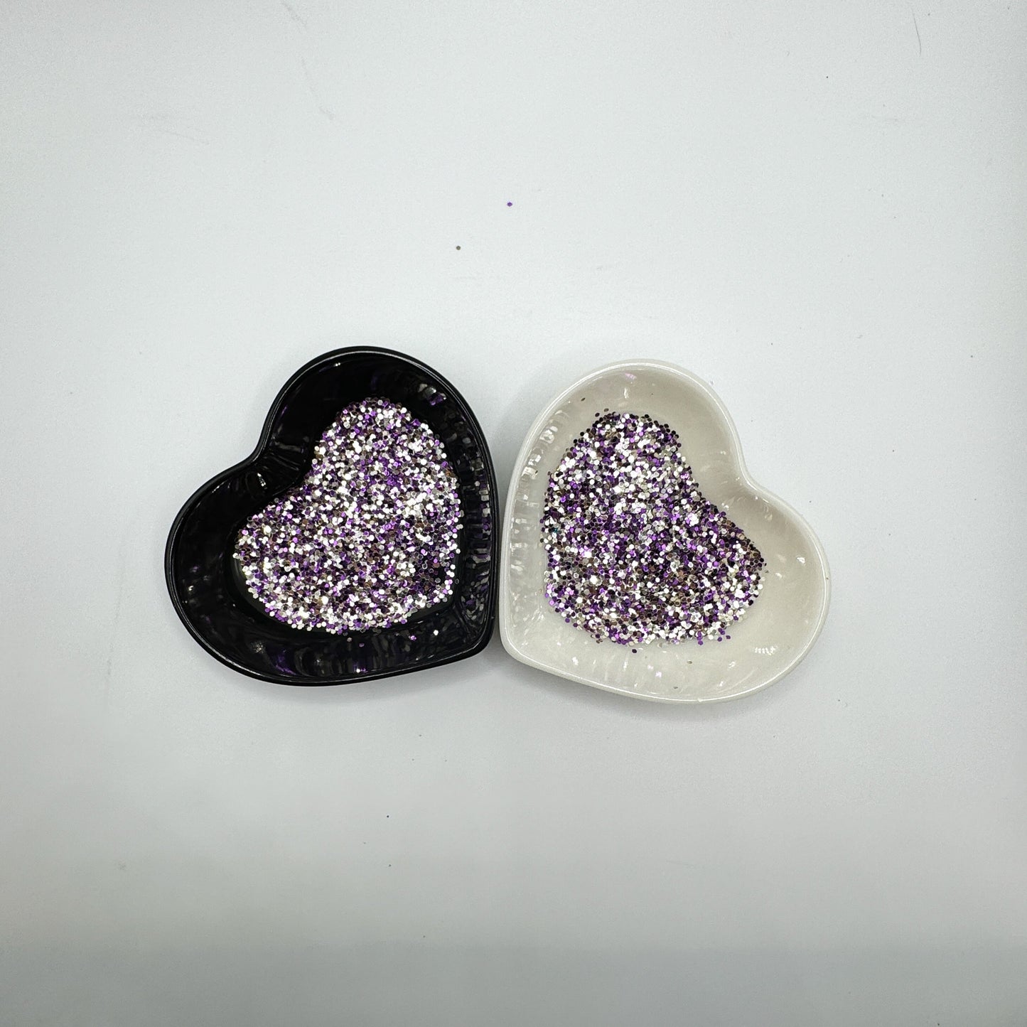A white and black heart shaped dish showing a Silver/Gold/Purple medium glitter mix.