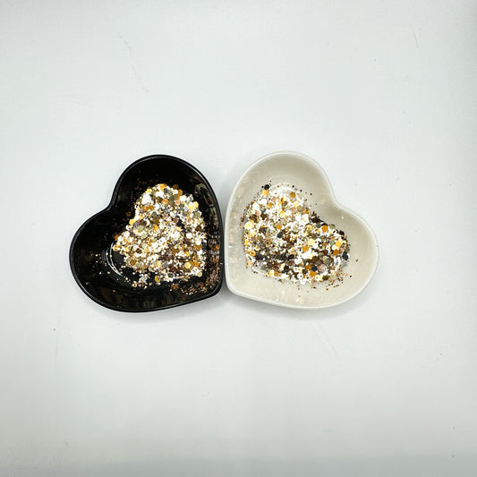 Two heart shaped containers, one black, one white, containing a Bronze/Gold/Silver/Rose Gold chunky glitter mix.