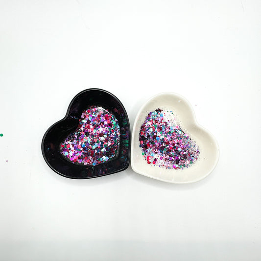 Two heart shaped containers, one black, one white, containing a Blue/Pink/Purple/Green chunky glitter mix.