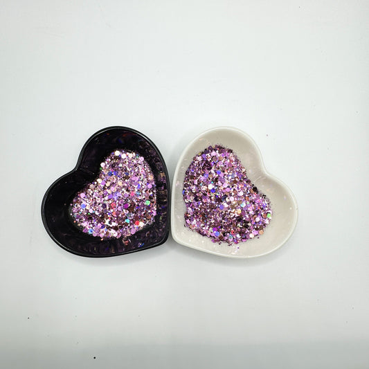 Two heart shaped containers, one black, one white, containing a Purple/Pink/Brown/Rose Gold chunky glitter mix.