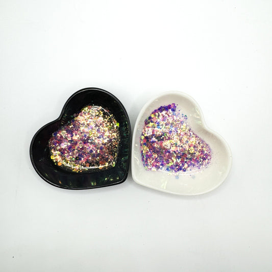Two heart shaped containers, one black, one white, containing a Blue/Green/Purple/Pink chunky glitter mix.