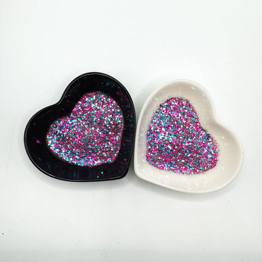 A white and black heart shaped dish showing a Pink/Blue/Purple/White medium glitter mix.