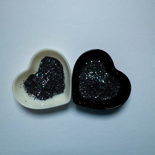 A white and black heart shaped dish showing a Black/Dark Purple/Dark Green medium glitter mix.