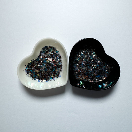 Two heart shaped containers, one black, one white, containing a Blue/Brown/White chunky glitter mix.