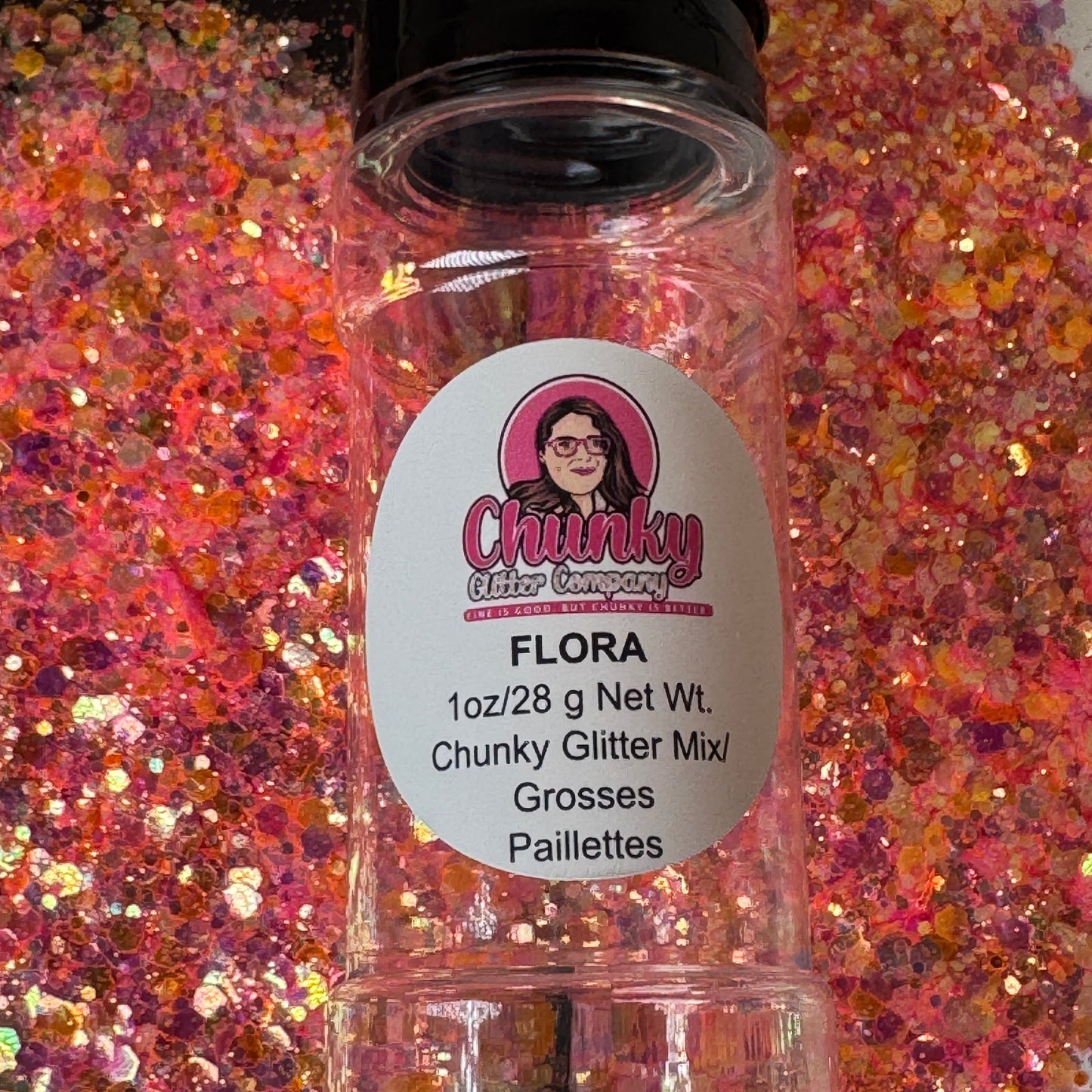 A clear plastic bottle with a label showing 'Flora' by Chunky Glitter Company, containing a Light Pink/Orange chunky glitter mix.