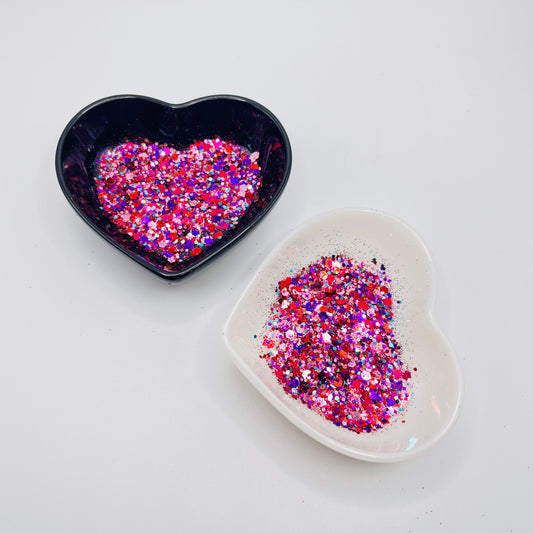 Two heart shaped containers, one black, one white, containing a Light Pink/Pink/Purple/Red/Blue chunky glitter mix.