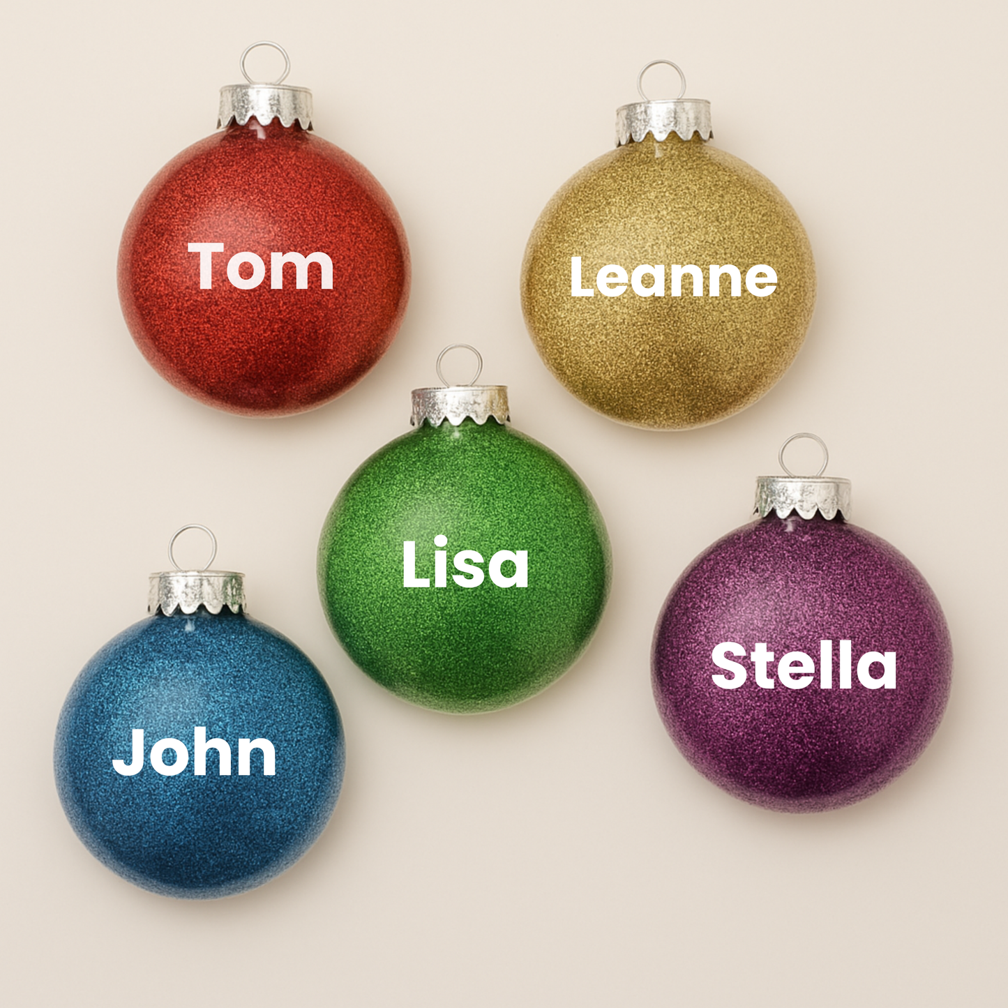 5 disc shaped glitter ornaments with the names Tom, Leanne, Lisa, John & Stella.