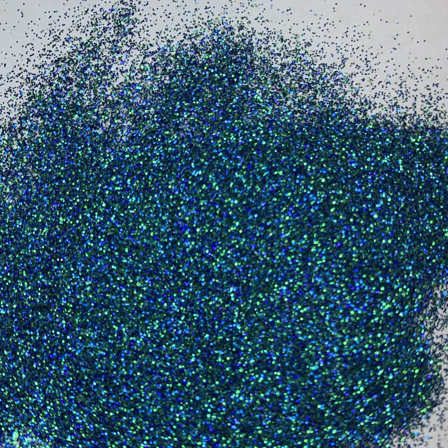 A close-up image of extra fine mix glitter showcasing various blues and greens.