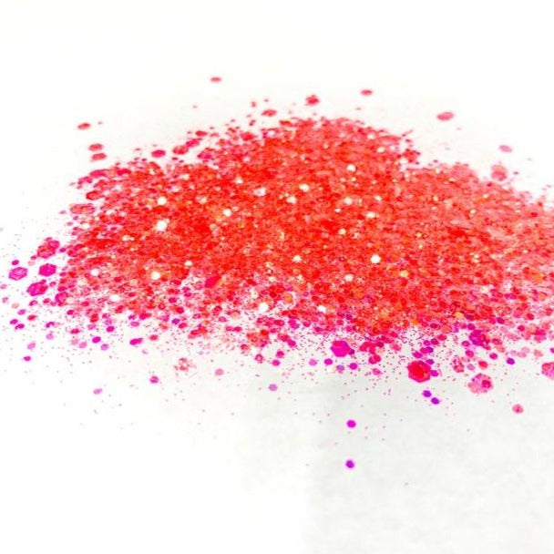 A coral chunky glitter mix on a white background.