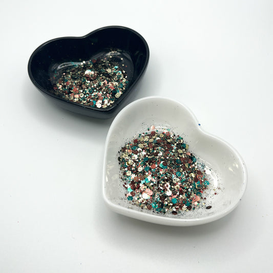 Two heart shaped containers, one black, one white, containing a Hunter Green/Brown/Gold chunky glitter mix.