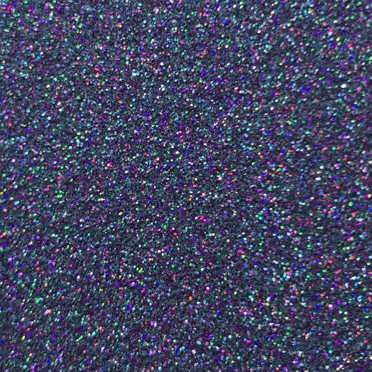 A close-up image of multicolored glitter, showcasing hues of turquoise, aqua, and purple.