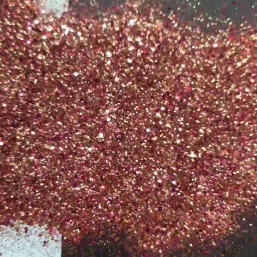 A close-up image of brown and gold colored polyester glitter, showcasing its texture and sparkle.
