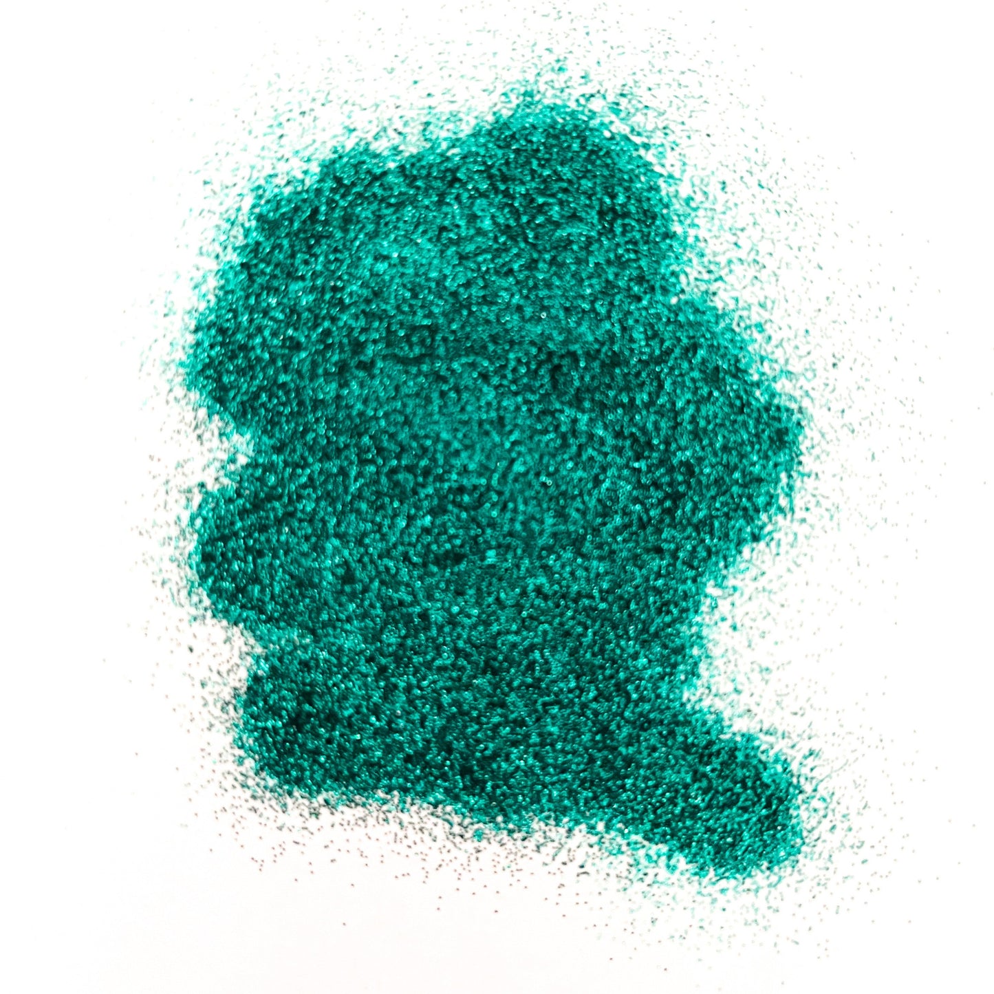 A pile of turquoise, extra fine glitter spread on a white surface.