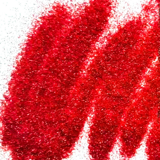 A close-up image of red polyester glitter spread out on a surface.