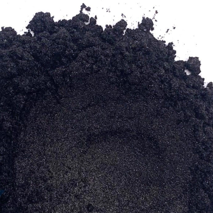 A pile of black mica powder on a white background.