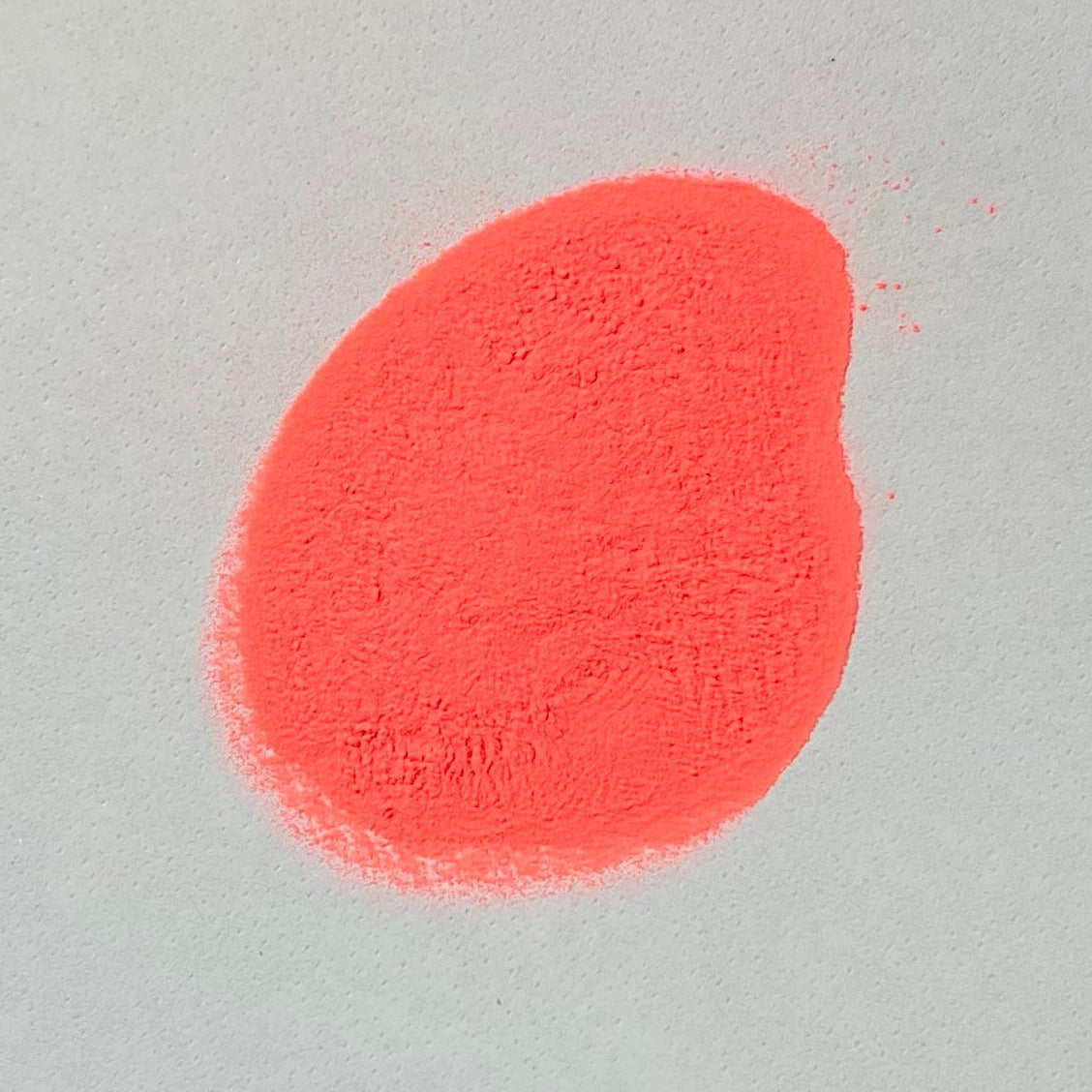 a pile of orange glow in the dark powder on a white background.