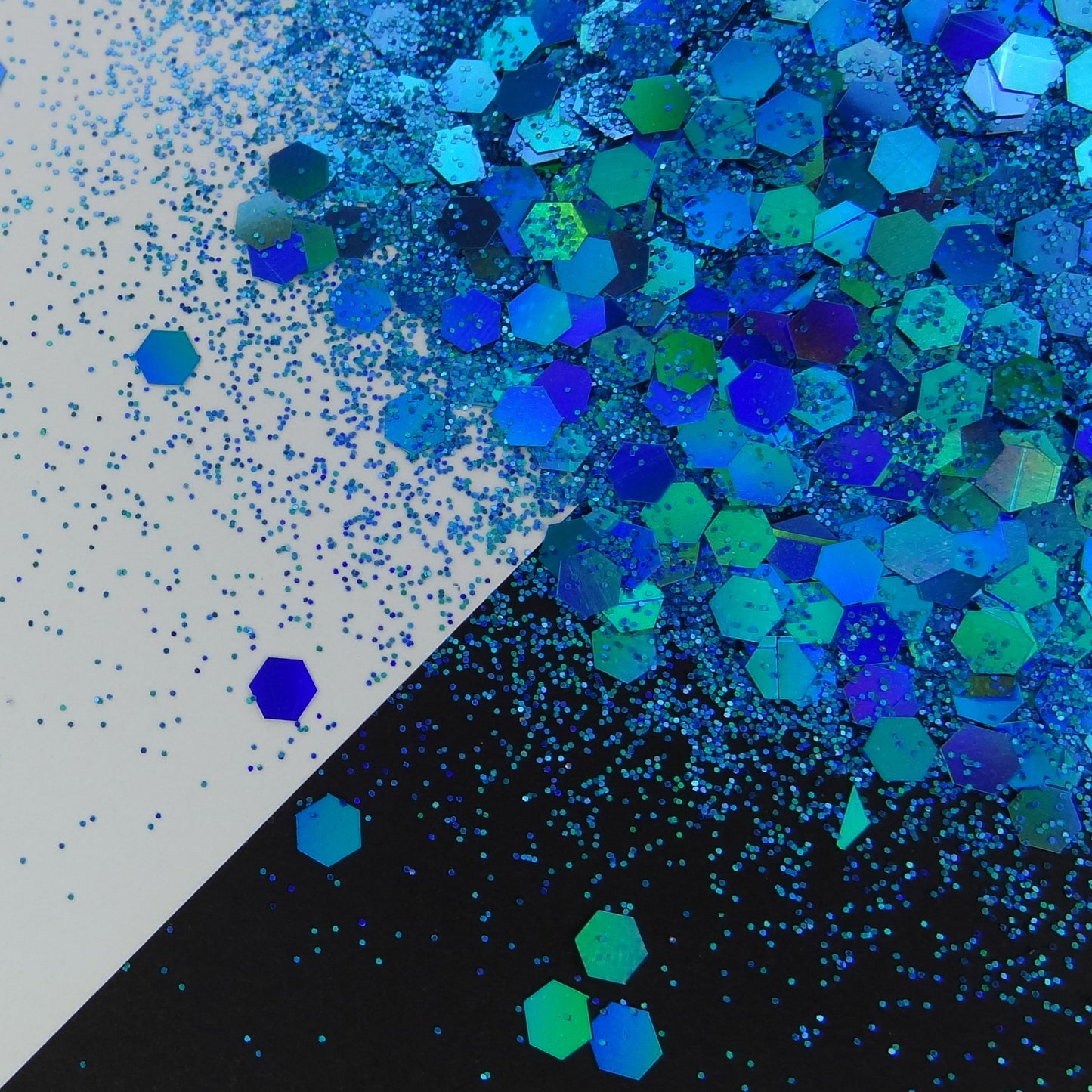 A blue holographic chunky glitter mix spread out on a black and white background.