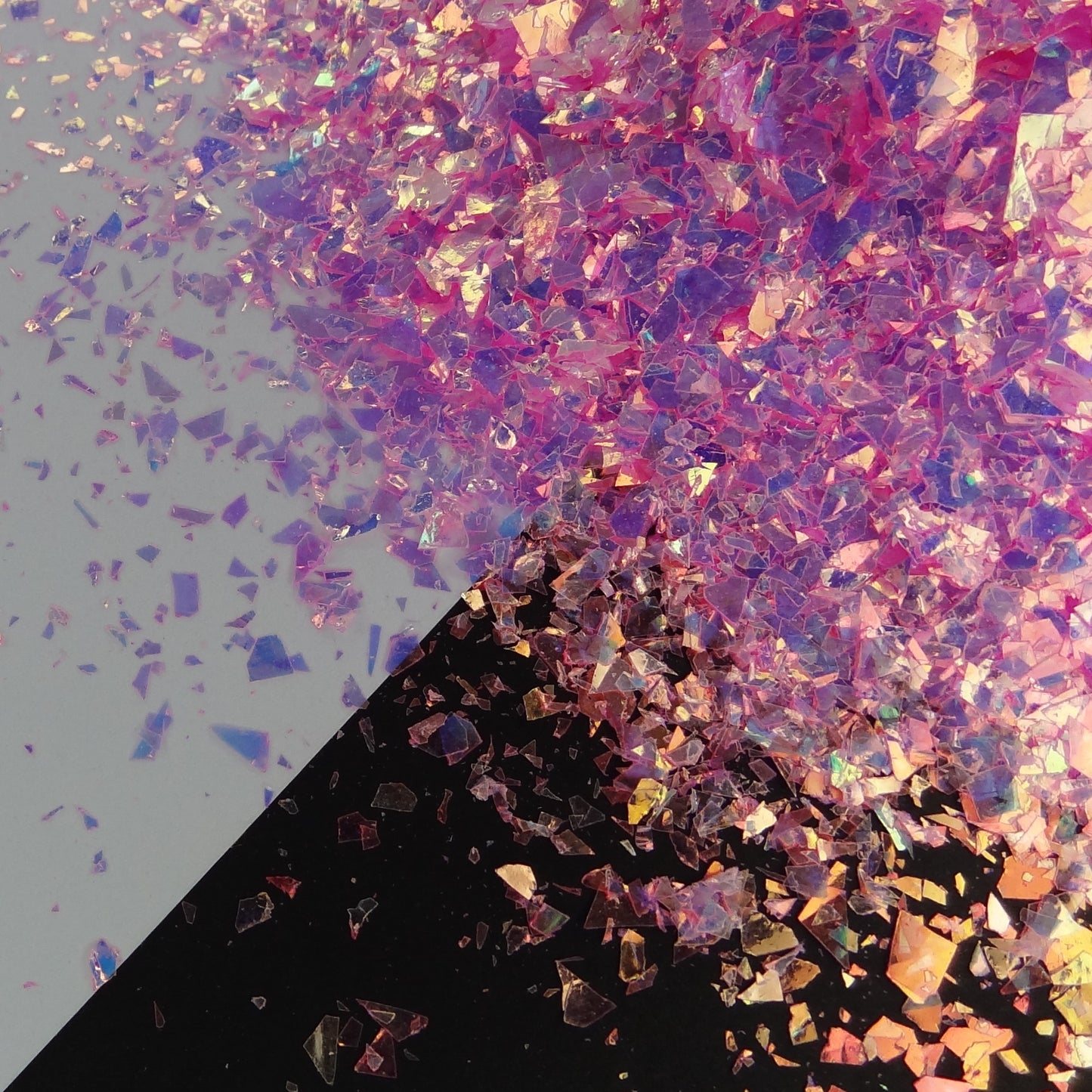 A pink irregular shard glitter spread out on a black and white background.