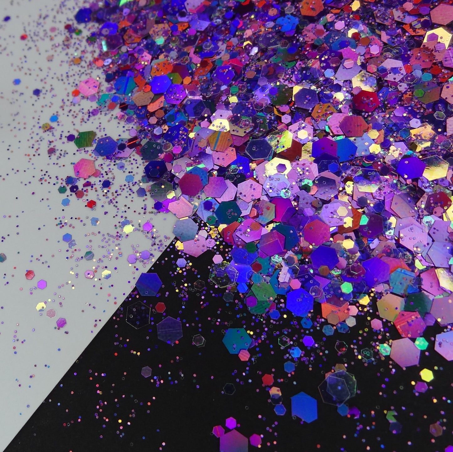 A pile of purple holographic chunky glitter on a black and white background.