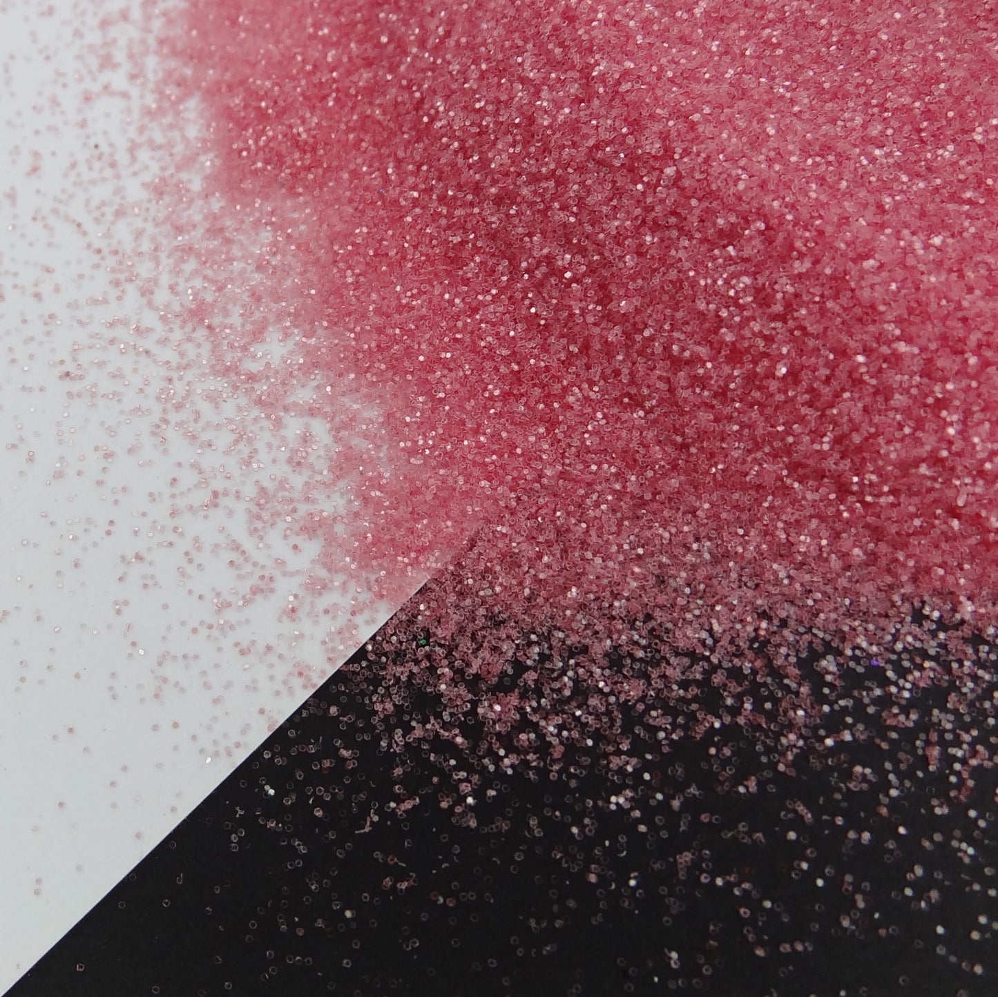 A dark peach extra fine glitter spread out on a black and white background.