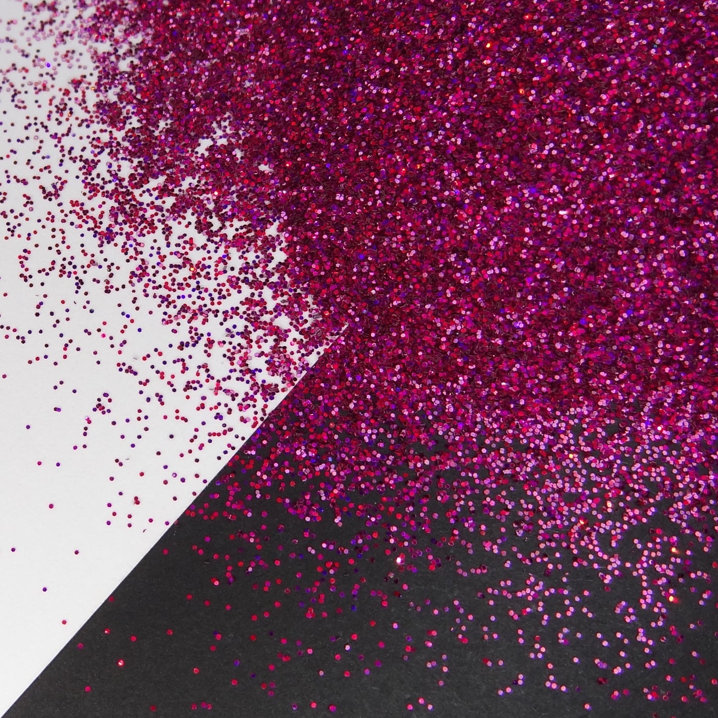 A holographic dark pink extra fine glitter on a white and black background.