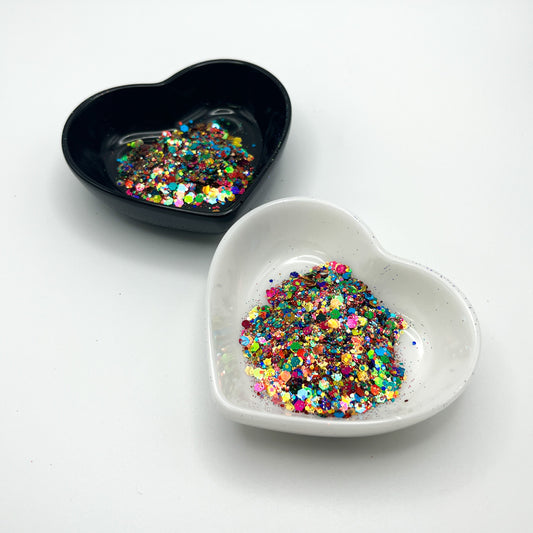 Two heart shaped containers, one black, one white, containing aPink/Teal/Green/Purple/Burnt Orange/Orange/Bronze chunky glitter mix.
