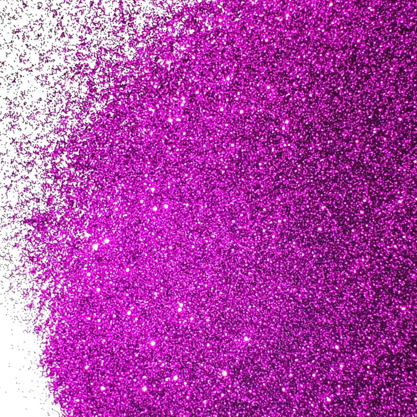 A close-up image of purple glitter spread on a surface, with varying shades of red and pink sparkle throughout.