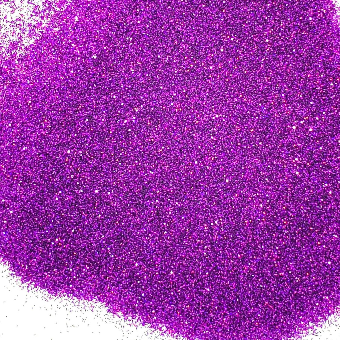 A pile of purple holographic glitter, in extra fine on a white background.