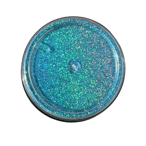 The bottom of jar of blue holographic glitter powder.