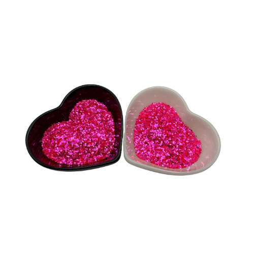 A white and black heart shaped dish showing a Pink medium glitter.