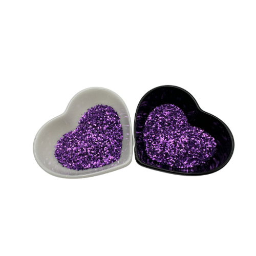 A white and black heart shaped dish showing a Purple medium glitter.