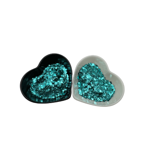 Two heart shaped containers, one black, one white, containing a Light Teal chunky glitter mix.