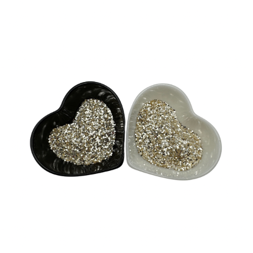 A white and black heart shaped dish showing a ligh gold medium glitter.