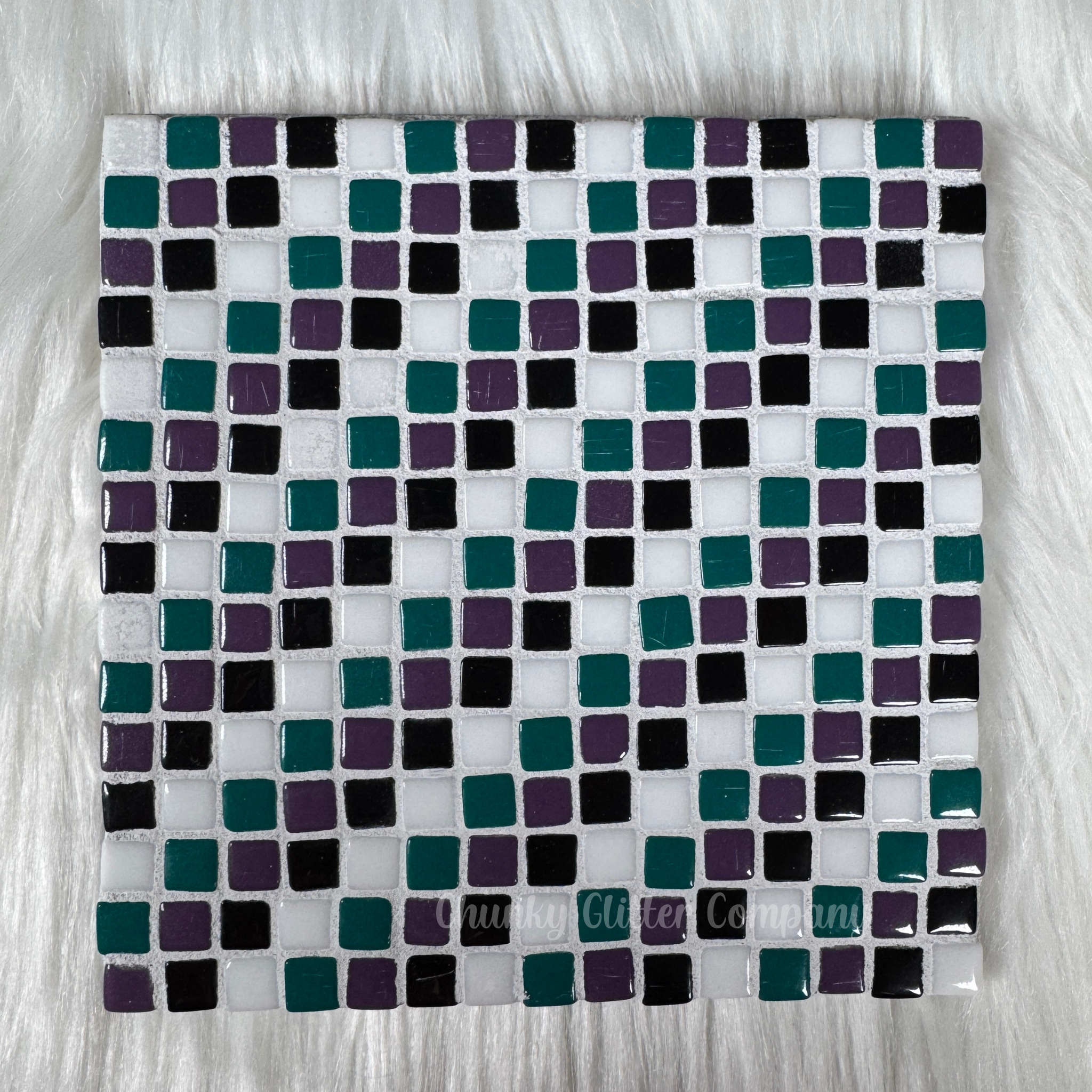 Square tile with a pattern of small squares in various colors on a white background