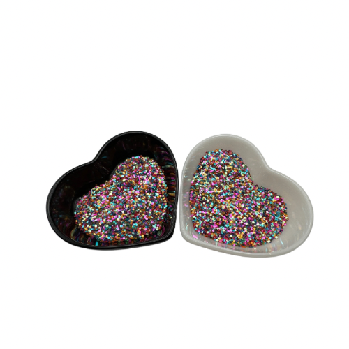 A white and black heart shaped dish showing Pink/Purple/Blue/Orange/Green medium glitter.