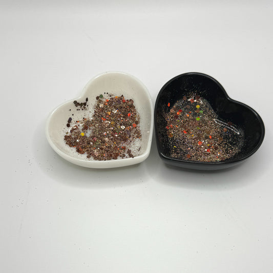 Two heart shaped containers, one black, one white, containing a Brown/Gold chunky glitter mix.