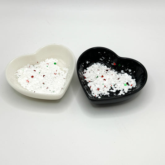 Two heart shaped containers, one black, one white, containing a White/Red/Green chunky glitter mix.