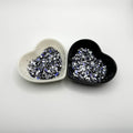 Two heart shaped containers, one black, one white, containing a Light Black/Blue/White chunky glitter mix.