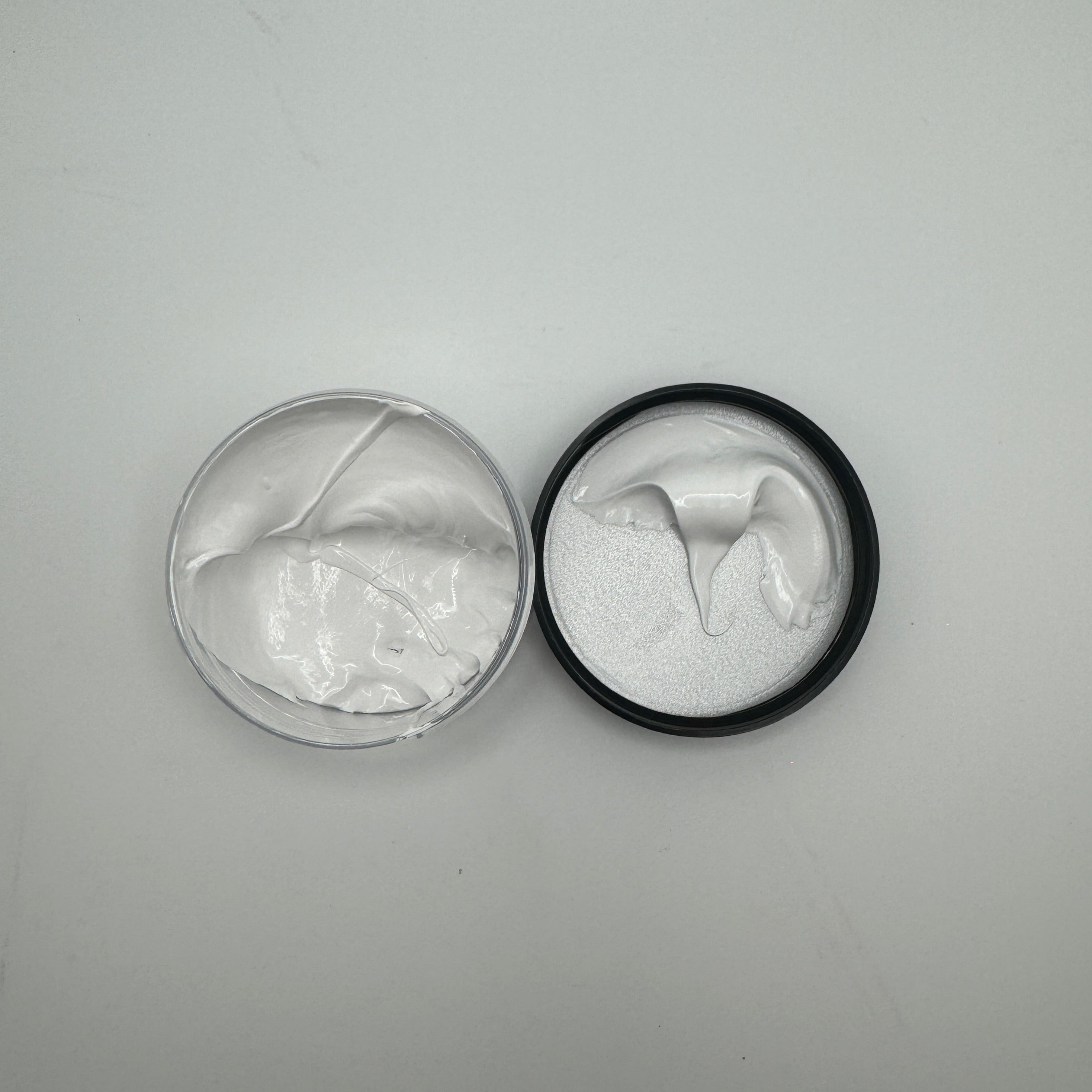 A container of white pigment paste open with product visible, on a white background.