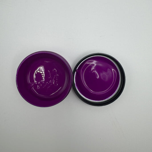 A jar of electric purple pigment paste opened to display the purple-coloured product inside.