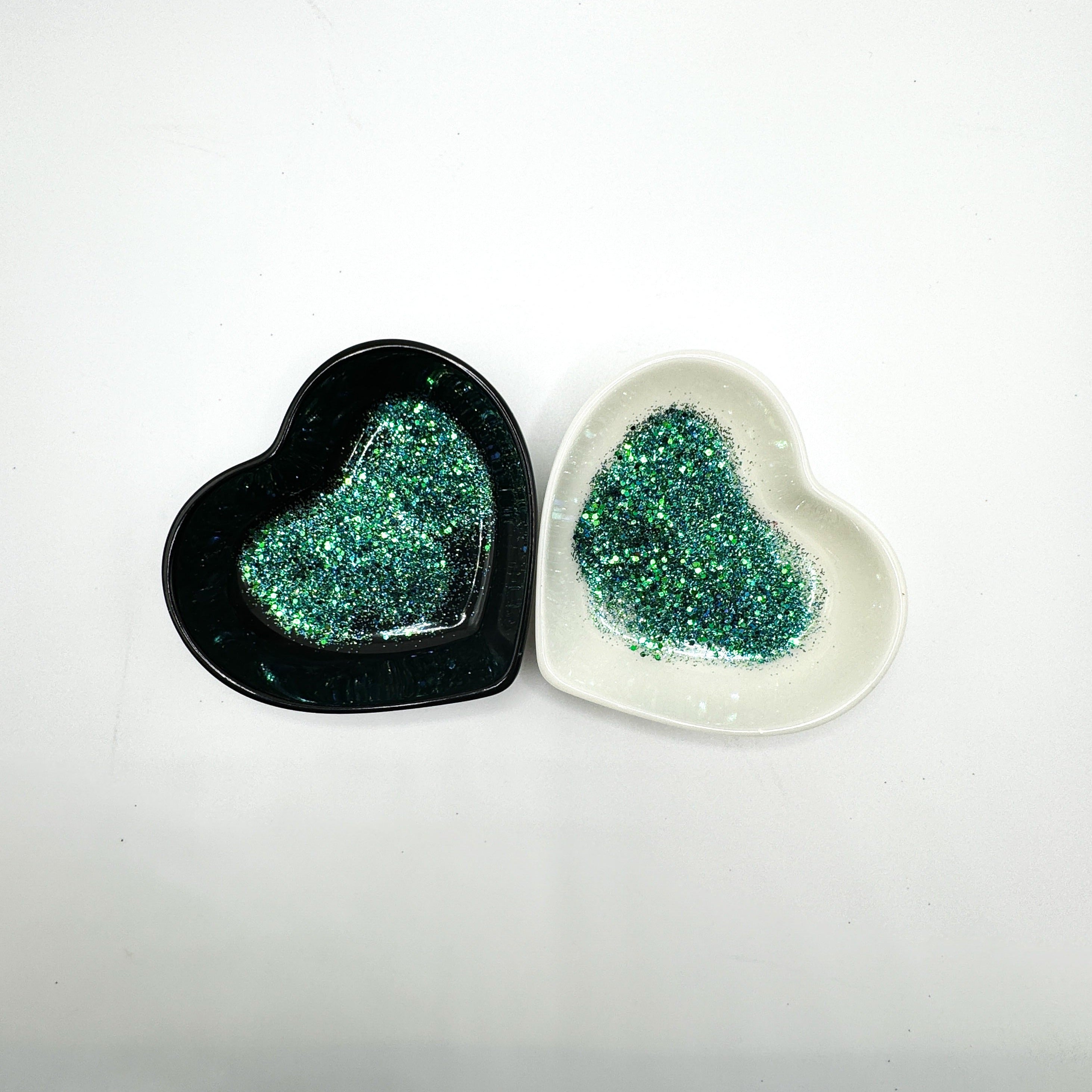A white and black heart shaped dish showing a Blue/Green medium glitter mix.