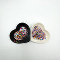 Two heart shaped containers, one black, one white, containing a Pink/Light Teal/Orange/Coral/Indigo chunky glitter mix.
